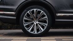 the front wheel of a black car with white spokes