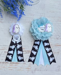 two ribbons that have been placed next to each other on a white table with blue flowers