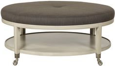 a round coffee table with wheels and a gray cushion on it's bottom shelf