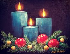 three blue candles with christmas decorations on them