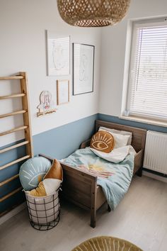 a bedroom with blue walls and wooden furniture, including a small bed in the corner