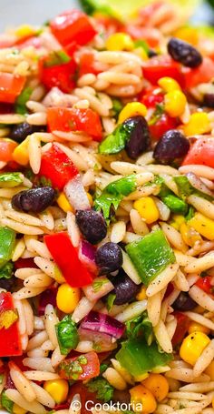 a colorful pasta salad with black olives, peppers and corn is ready to be eaten