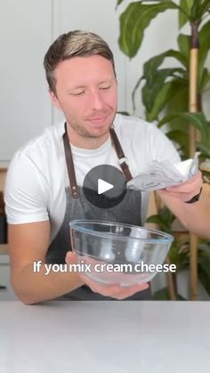 a man in an apron mixing cream into a bowl