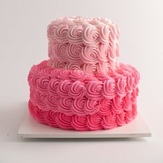 a three layer cake with pink frosting on top