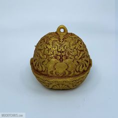 an ornately decorated gold box on a white background