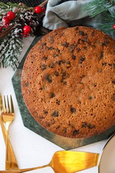 a chocolate chip cake sitting on top of a table next to silverware and christmas decorations