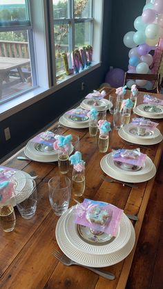 the table is set with plates, cups and napkins for a baby shower party