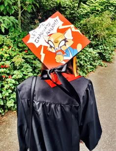 a person wearing a graduation cap with cartoon characters on it's side and writing that says happy new year