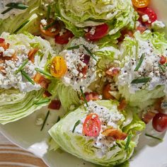 lettuce and tomato salad with feta cheese on white plate sitting on wooden table