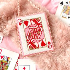 a cross stitch card holder with playing cards