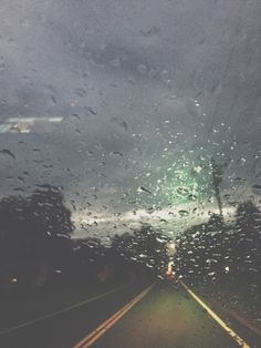 rain is falling on the windshield of a car