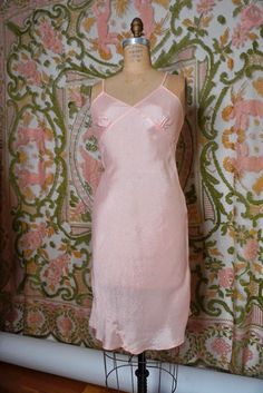 A lovely pale pink slip. Luxe, silk-like rayon typical to loungewear of the era. This garment does not have any stretch, but the bias cut does offer a bit of wiggle room. Size XS. 33" chest, up to 27" waist, up to 34" hips, 34.5" long. 100% rayon. Made in the USA. 1940's-50's Fitted Satin Slip Dress For Loungewear, Pink Spring Slip Dress With Bias Cut, Spring Pink Slip Dress With Bias Cut, Spring Pink Bias Cut Slip Dress, Pink Fitted Silk Slip Dress, Fitted Silk Slip Dress In Pink, Spring Bias-cut Slip Dress For Loungewear, Pink Bias Cut Slip Dress For Spring, Fitted Bias Cut Slip Dress For Sleep