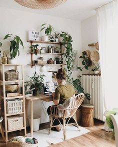 a person sitting at a desk in front of plants