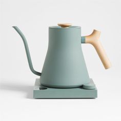 a tea pot with a wooden handle on a stand