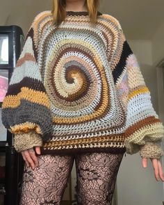 a woman in tights is wearing a multicolored crochet knit sweater