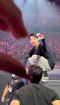 the man is doing tricks on his skateboard in front of an audience at a concert