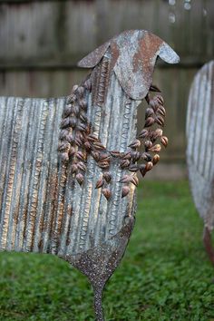 an old metal horse is standing in the grass