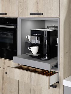 a coffee maker is in the middle of an open cabinet