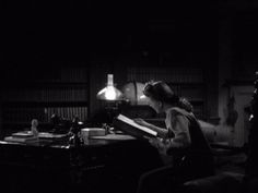 a woman sitting at a desk in the dark