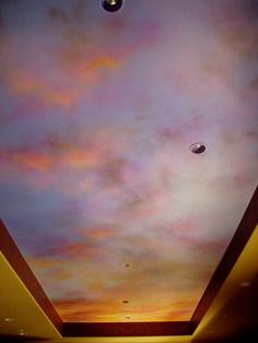 the ceiling is painted with colorful clouds and planets