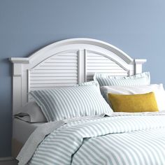 a bed with blue walls and white headboard