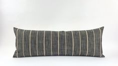 a gray and white striped pillow sitting on top of a table