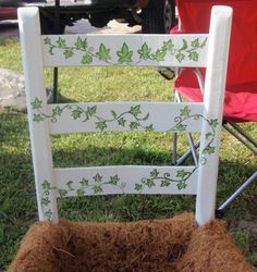 a chair that has been decorated with vines and leaves on it, sitting in the grass