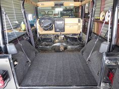 the interior of a vehicle with its doors open and steering wheel in place on the floor