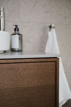 a bathroom with a sink, soap dispenser and toiletries on the counter