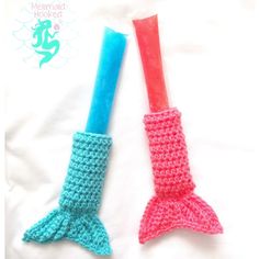 two crocheted mermaid tail shaped toothbrush holders sitting next to each other on a white sheet