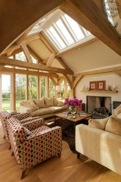 a living room filled with furniture and a fire place in the middle of an open floor plan