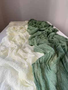 there are three different colors of towels on the bed together, one is green and white