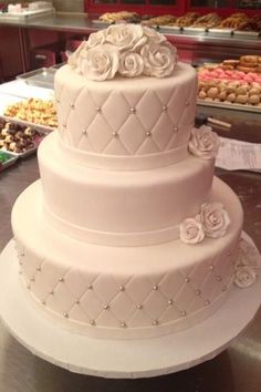 a three tiered wedding cake with roses on the top is shown in an instagram