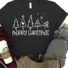 a t - shirt that says merry christmas surrounded by other holiday items and accessories, including a coffee cup