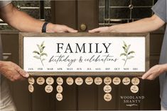 two people holding up a sign that says, family birthday and celebrations with leaves on it