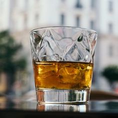 a glass filled with ice sitting on top of a table