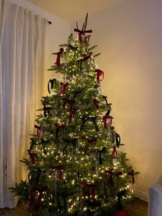 a decorated christmas tree with red and black bows