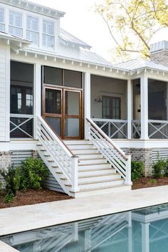 a house with a pool in front of it and stairs leading up to the second floor