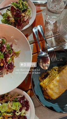 three plates with food on them sitting on a table next to glasses and silverware