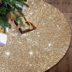 a gold table with presents on it and a christmas tree in the corner next to it