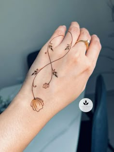 a woman's hand with tattoos on it and a flower tattoo on the wrist