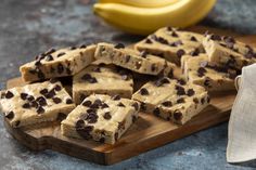 chocolate chip cookie bars on a cutting board next to a banana