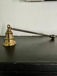 an antique brass bell on top of a black desk