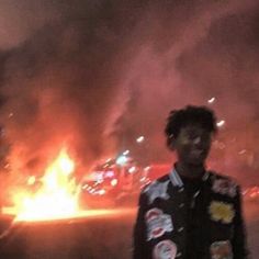 a man standing in front of a fire that has been set alight from the sky