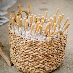 a basket filled with lots of bottles sitting on top of a cement floor next to a wooden handle