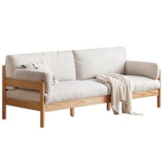 a white couch sitting on top of a wooden frame next to a blanket and pillow