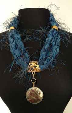 This ribbon scarf/necklace is made with a variety of specialty ribbons and yarns from around the world. Done in shades of blue a   This ribbon scarf necklace come with gold jewelry and an interchangeable pendant.  This is a ResQ™ product so 10% of the profits go to help the fight against human trafficking.  FREE SHIPPING Ribbon Scarf, Textile Necklace, Scarf Necklace, Chair Decorations, Ann Arbor, Scarf Jewelry, Blue Ribbon, Bead Designs, Arbor