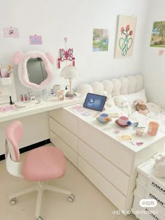 a white desk with a laptop computer on top of it next to a pink chair