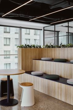 an office with planters on the wall and tables in front of it, along with benches