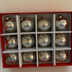 a red box filled with silver christmas ornaments